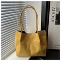 Dettaglio della borsa tote in pelle scamosciata gialla con texture morbida e cuciture - Giallo