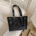 Detail der schwarzen Shopper-Tasche mit Silberring und verstellbarem Riemen auf Sofa - Schwarz