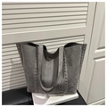 Dettaglio borsa tote grigia in pelle scamosciata con borchie argentate e manici - Grigio