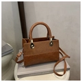 Detail view of retro brown crossbody bag with mixed leather texture and woven handle - Brown