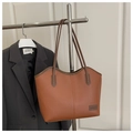 Detalle del bolso tote marrón grande con textura de cuero y etiqueta de moda en el soporte - Marrón