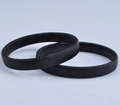 Detail of two black metal spring sleeve garters for men on a neutral grey background - Black