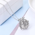 Dettaglio macro di un ciondolo a gabbia apribile in argento con motivi floreali intricati - Medaglione Sferico Traforato (Include 5 Palline di Cotone 1 Pietra Lavica) / Bianco K/Argento