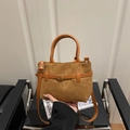 Vintage Beuteltasche aus braunem Wildleder mit Lederriemen und Schnalle von Model gehalten - Braun