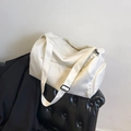 Minimalistische weiße Nylon-Tragetasche mit verstellbarem Gurt auf Ledersitz - Gebrochenes Weiß