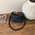 Minimalist black tote bag with vertical texture and gold lock on a wooden table - Black