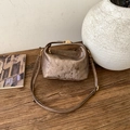 Detailed macro view of vintage bronze textured small square bag with metallic buckle - Brown