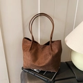 Minimalist large brown matte leather tote bag for women on stylish book with soft lighting - Brown