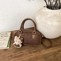 Borsa Boston marrone maculata con ciondolo in peluche e manici su un tavolo di legno - Caffè (Senza Pendente)