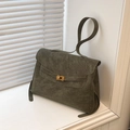 Borsa tote verde oliva opaca con chiusura a rotazione dorata in un ambiente interno pulito - Verde
