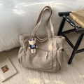 Dettaglio borsa tote in velluto a coste kaki con tasca a zip e ciondolo a orsetto - Cachi (Senza Ciondolo)