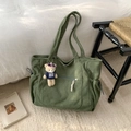 Dettaglio della borsa tote in velluto a coste verde con tasche a coulisse e ciondolo a orso - Verde Senza Pendente