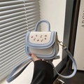 Detail of mini cherry print bag featuring light blue flap and gold metal fastener - Blue