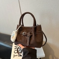 Minimalist matte dark brown bucket bag with silver buckle and plush keychain detail - With Pendant / Brown