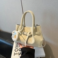 Matte beige bucket bag with decorative buckle and plush pendant charm on handle - With Pendant / White