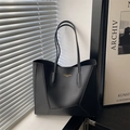 Minimalist black faux leather tote bag with geometric stitching and gold letter branding - Black