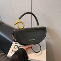 Bolso montura negro minimalista en cuero mate con detalles dorados y asa circular - Negro