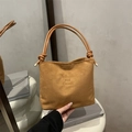 Vintage braune Bucket Bag aus Wildleder mit verstellbarem Gurt auf weißem Sockel - Braun