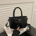 Fashionable black patent leather crossbody bag with silver buckle and curved top handle - Black