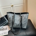 Elegante borsa tote grigia con manici neri e anelli dorati in un ufficio - Nero