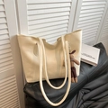 Minimalist beige leather tote bag with a cute brown plush rabbit pendant on a black sofa - With Pendant / White