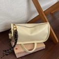Cream-colored square handbag with tennis racket charm placed on vintage books - Without Pendant / White
