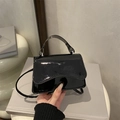 Bolso de mano minimalista en cuero charol negro con solapa ondulada y correa ajustable - Negro