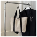 Detail view of woven straw tote bag in off-white hanging on a silver hanger - Off White