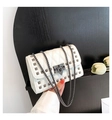 Detail van witte gewatteerde tas met vierkante metalen studs en een verfijnde schouderketting - Wit