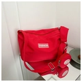 Dettaglio della borsa a tracolla in tela rossa con portamonete rotondo e logo di moda - Rosso