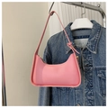 Bolso hobo rosa de cuero PU con cremallera dorada sobre fondo de chaqueta vaquera - Rosa