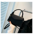 Nahaufnahme der schwarzen Handtasche mit Fischgrätmuster und eleganten goldenen Beschlägen - Schwarz