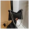 Close-up of black handbag featuring high-density rhinestones and shimmering chain strap - Black