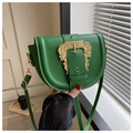 Detailed close-up of green PU leather saddle bag with golden baroque relief buckle - Green