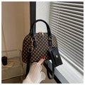 Detailed close-up of brown monogram shell bag with black handle and gold hardware - Black
