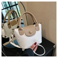 Detail der weißen Lychee-Lederstruktur und braunem Griff einer Vintage-Beuteltasche - Weiß
