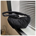 Borsa a spalla trapuntata nera con dettaglio nodo sul manico su un davanzale - Nero