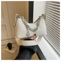 Close-up of a white crescent shoulder bag featuring chunky silver chain and round pendant - White