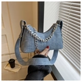 Close-up of light blue crescent moon bag with silver chain and wide shoulder strap - Denim Blue