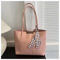 Pink matte PU leather tote bag with a plaid silk scarf detail on the handle in home setting - Pink
