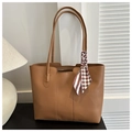 Close-up of brown PU leather tote bag with elegant silk scarf detail on the handle - Brown