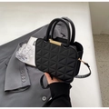 Detalle de bolso negro de cuero PU acolchado con barra de metal dorado y asas top - Negro