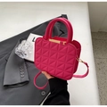 Detailed macro view of hot pink handbag featuring 3D geometric triangular stitching and gold metal hardware - Rose Red