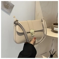 Nahaufnahme der beigen Lederhandtasche mit goldener Schildschnalle und Knotenschultergurt - Khaki