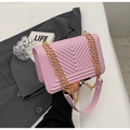 Borsa a tracolla trapuntata rosa con catena dorata su sfondo urbano raffinato - Rosa
