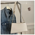 Detalle de bolso bandolera de cuero PU blanco con cadena dorada en percha de ropa - Blanco