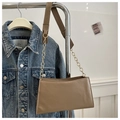 Detalle de bolso bandolera marrón claro con costuras blancas y correa de cadena dorada - Caqui