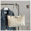 Detail of white quilted tote bag with V-shaped stitching and golden chain strap on a hanger - White