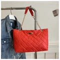 Detail of red quilted tote bag with gold chain strap and metallic front plaque - Red