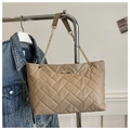 Close-up of khaki quilted tote bag with golden chain strap and chevron pattern detail - Khaki